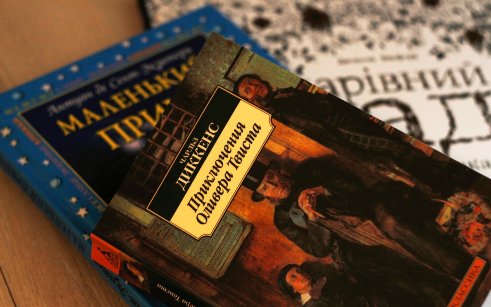 Stacked books including Russian editions of Oliver Twist and The Little Prince
